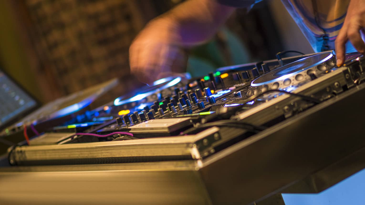 DJ at turntable with lights at night