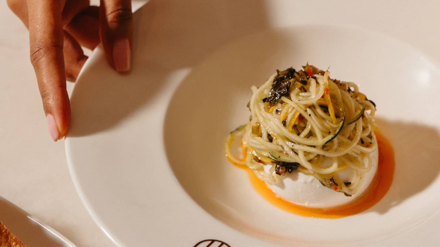 Burrata and courgette escabeche served in a wide-rimmed white bowl