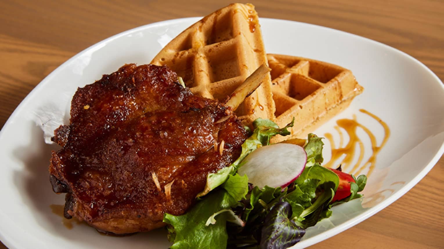 A dish with waffles and vegetables on the side