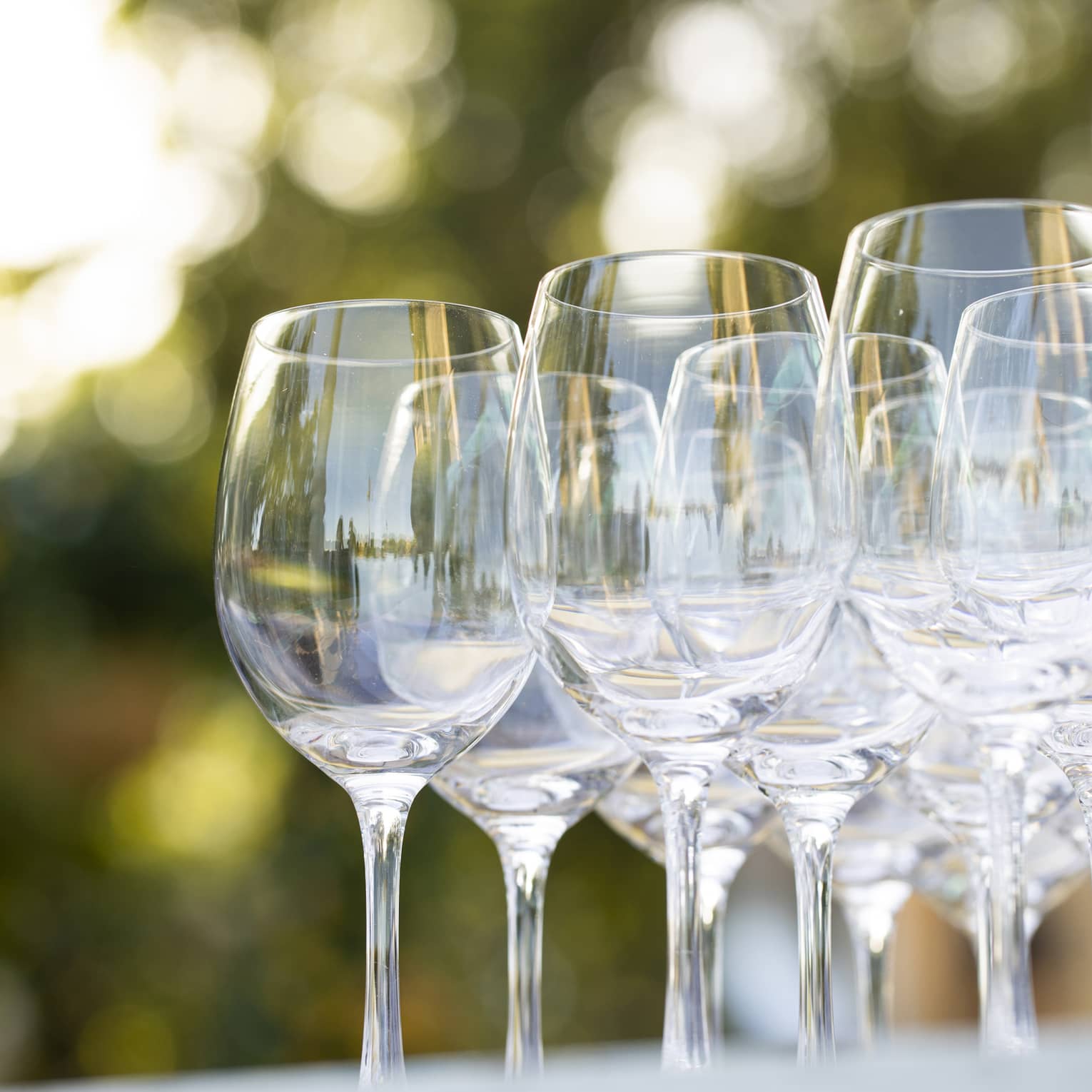 Empty wine glasses grouped together on an outdoor table