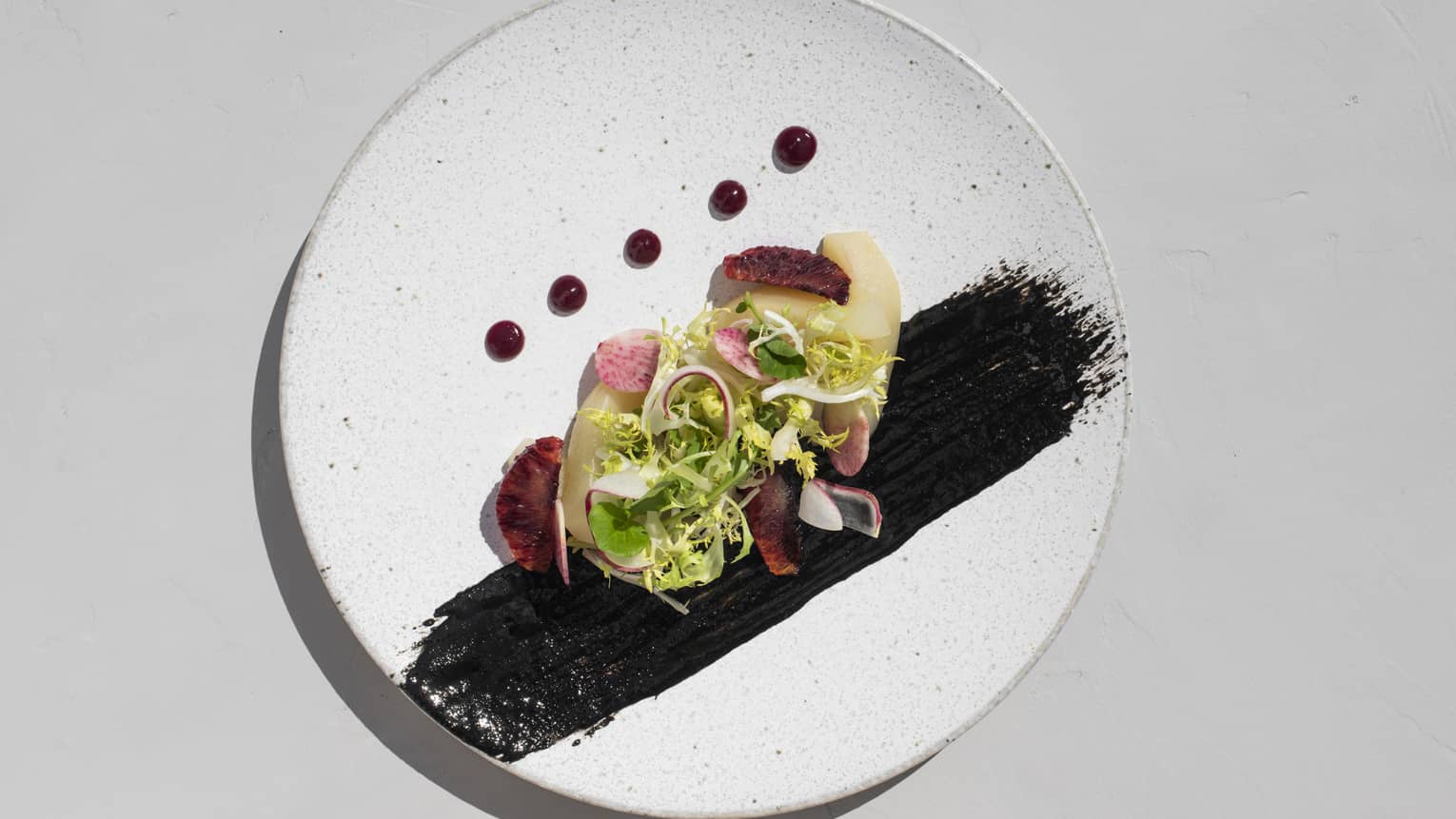 Gourmet sashimi with greens garnish and artistically placed sauces