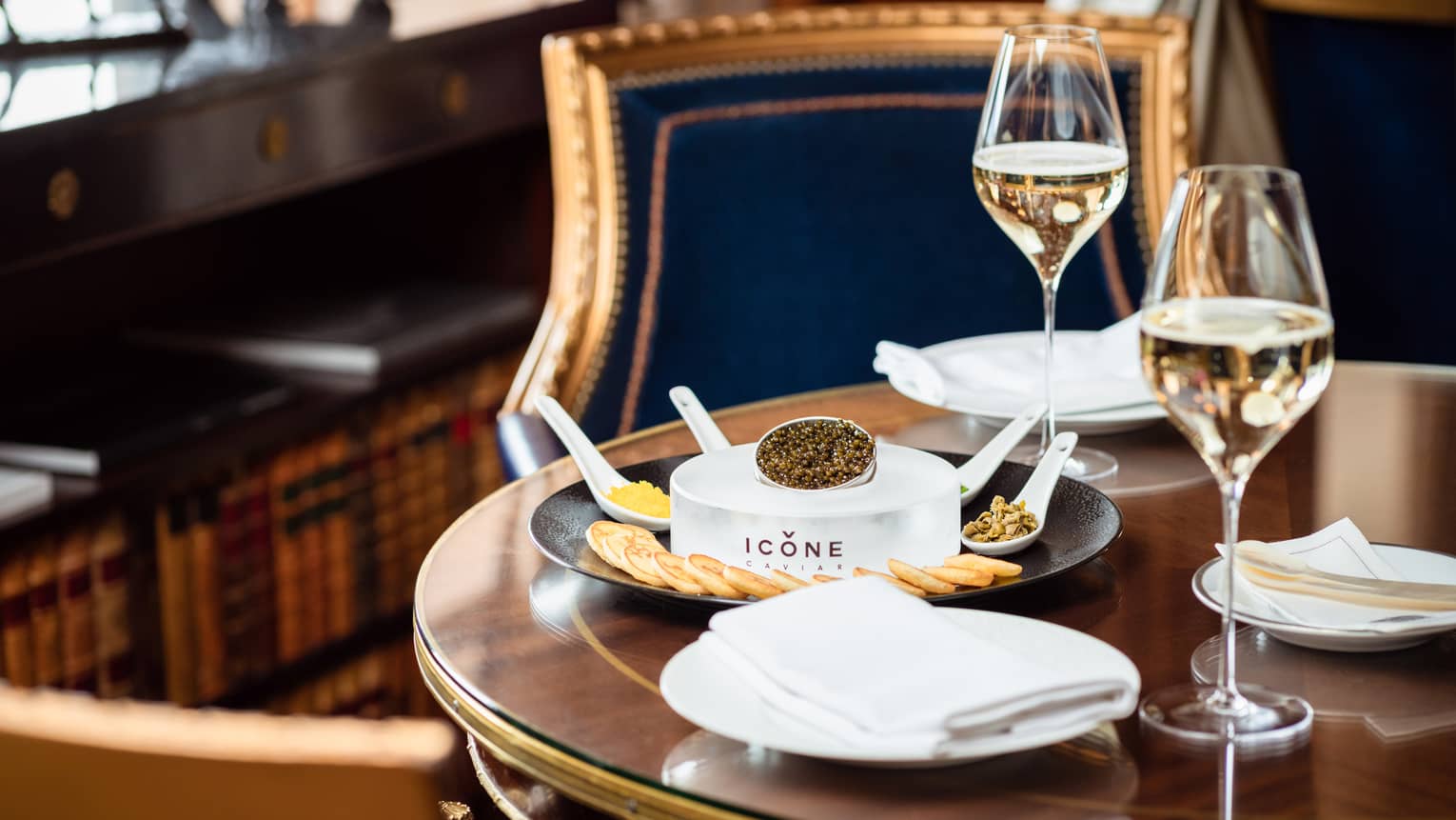 Caviar and crackers next to glasses of wine.