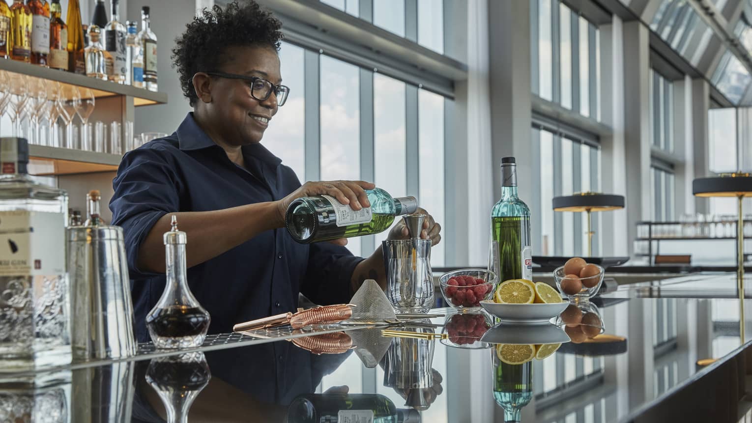 A four seasons bar tender pours a drink at the bar