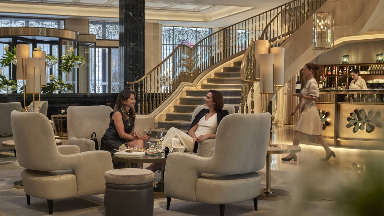 Two women having afternoon tea in main hall of the former Banco Español de Crédito, Madrid
