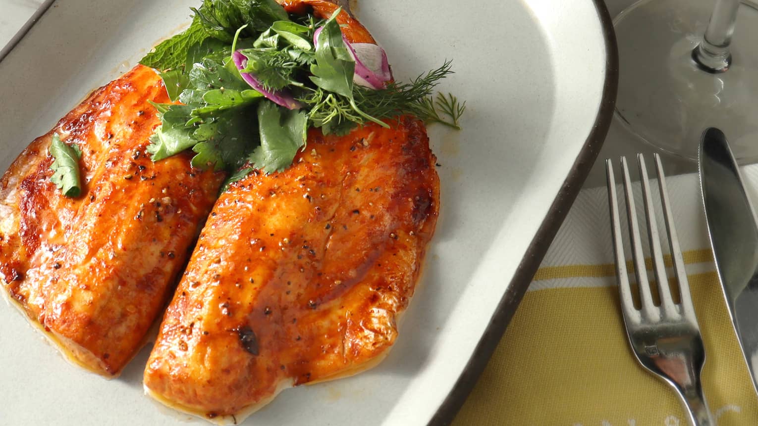 A large piece of fish on a white plate.