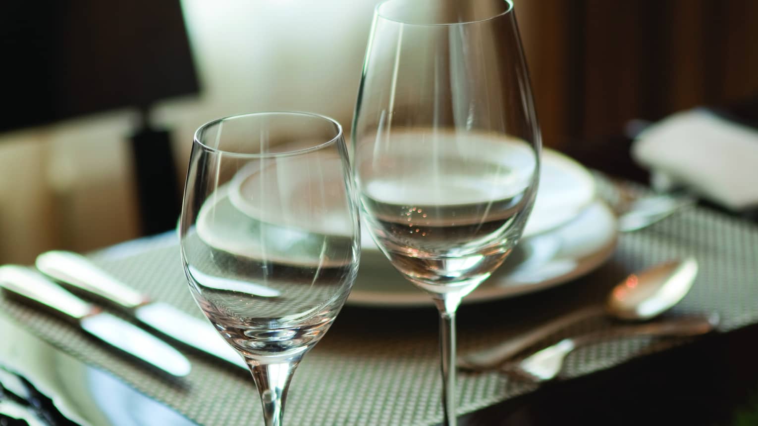 Two wine glasses on hotel room dining table