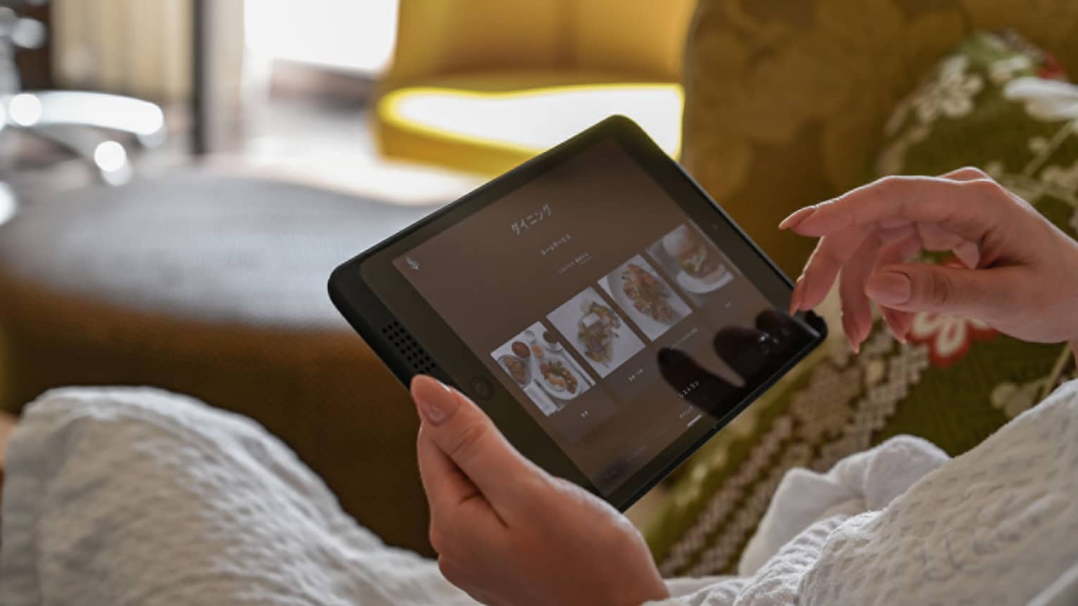 Guest using an in-room tablet to browse dining options