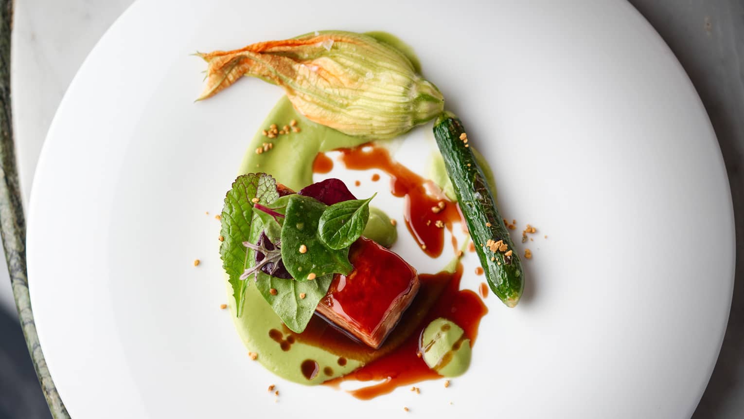 Lamb and zucchini with a red sauce.