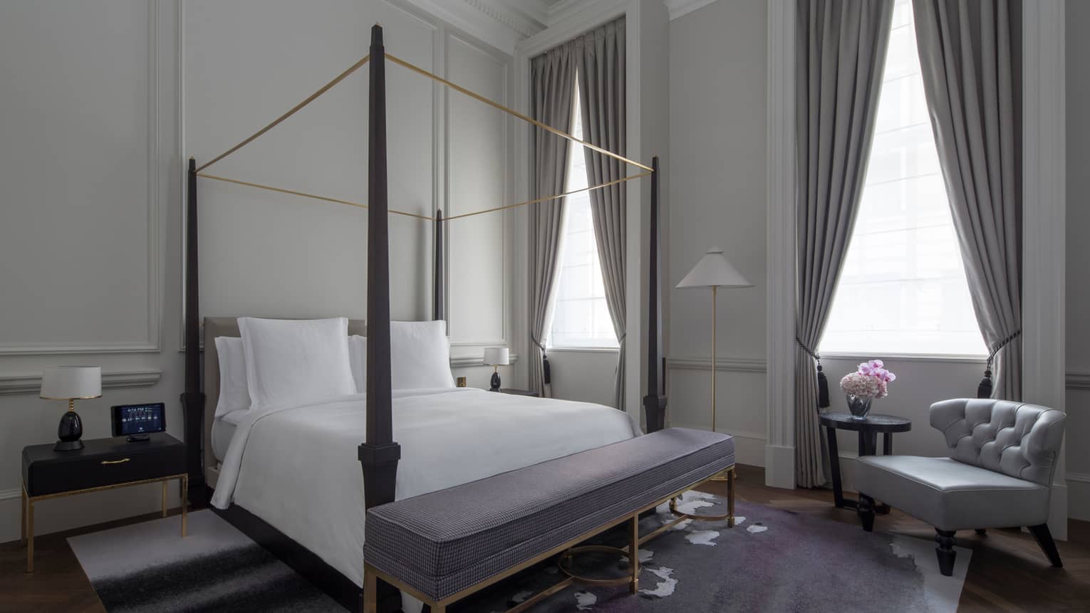 Grand Heritage Suite bed with canopy bed, padded bench, high ceilings, white walls with original columns