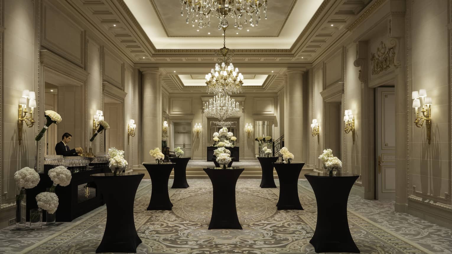 Monochromatic wedding venue with beautiful white flowers on black pillar tables