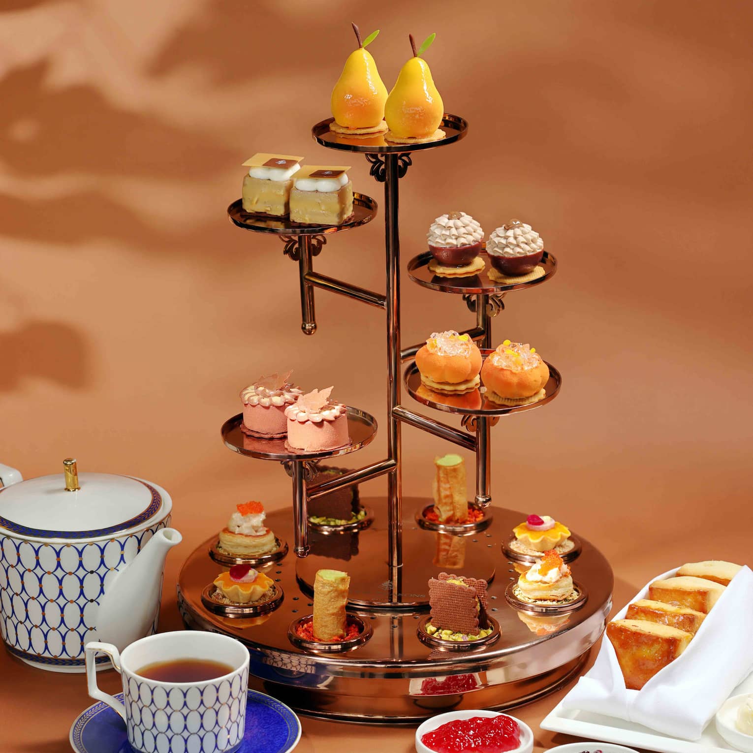 Afternoon tea display with sweet and savoury delicacies in warm autumnal colours
