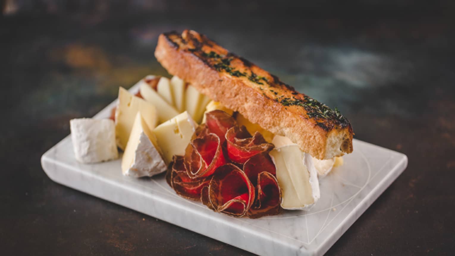 A fish filet served with a variety of cheeses.