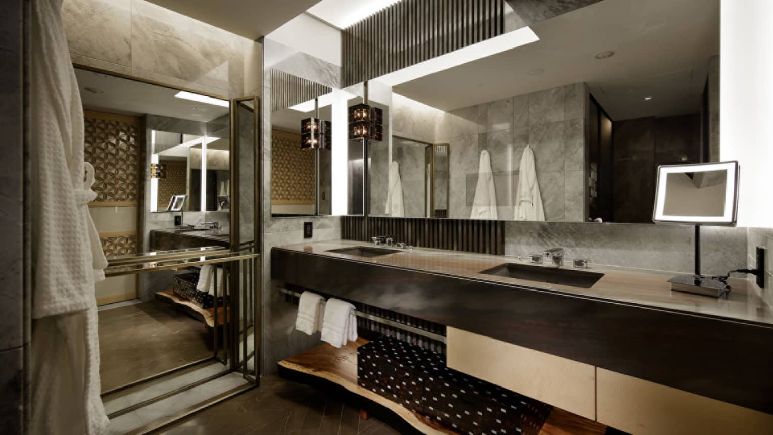 Bathroom with double vanity, walk-in shower, illuminated make-up mirror and two hanging bathrobes