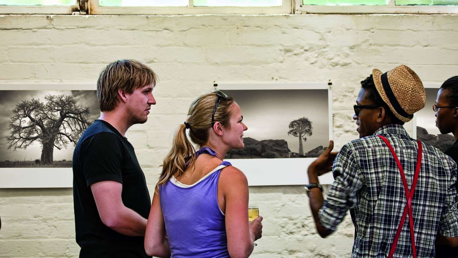 Four people discuss black and white art prints at Museum in Maboneng 