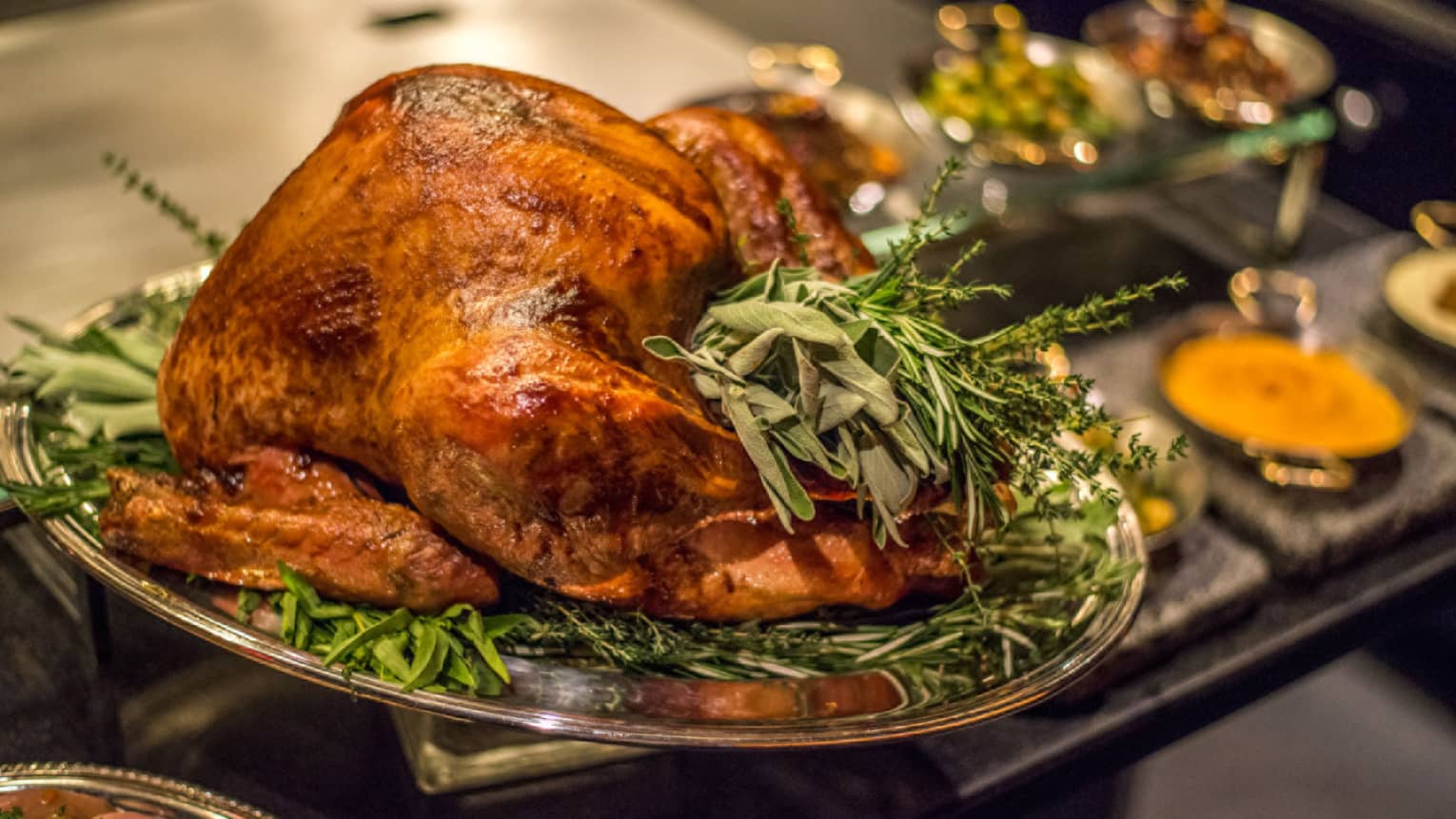 Roast turkey with fresh herbs on silver platter