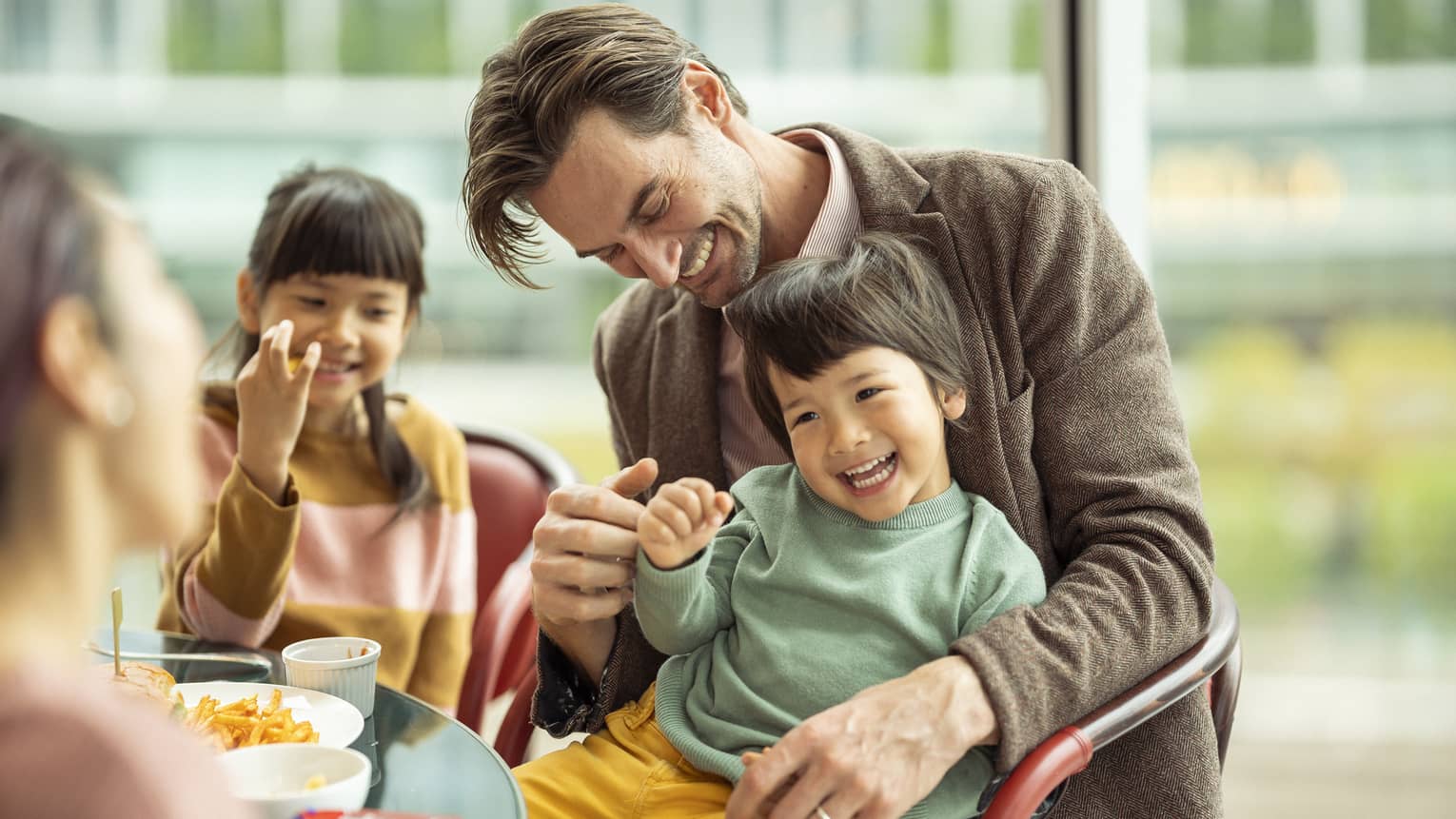 Laughing couple and kids enjoy a meal together