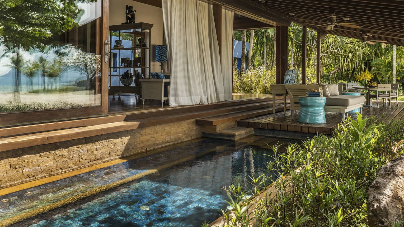 White curtains hang from Beach Villa patio over tile plunge pool