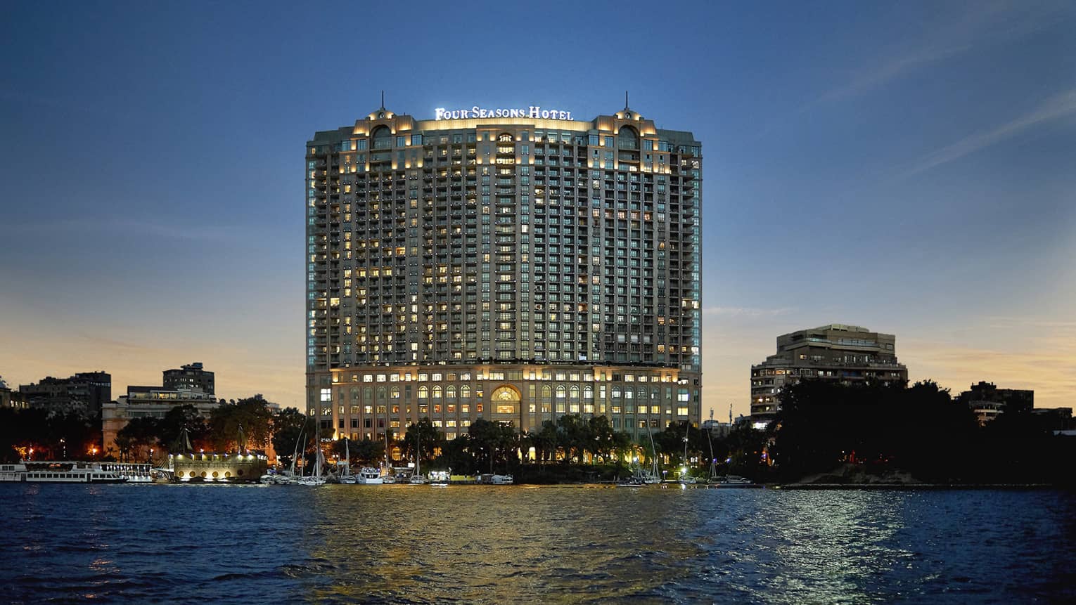 Hotel exterior illuminated at night with the Nile River below