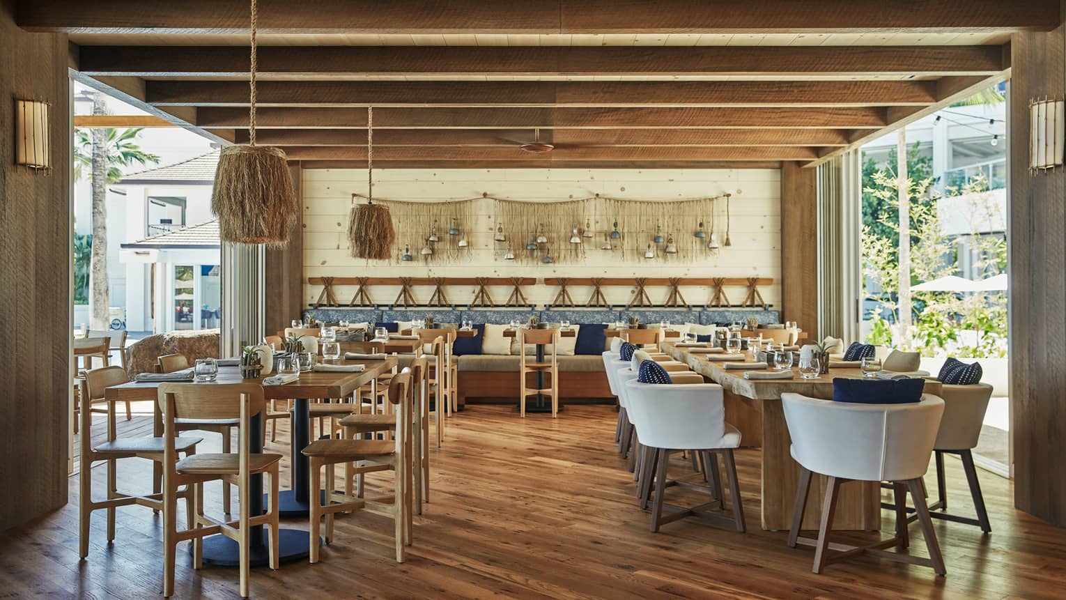 Minas bar with retro-style tiki tables and chairs, shaggy lamps, decorative fish net