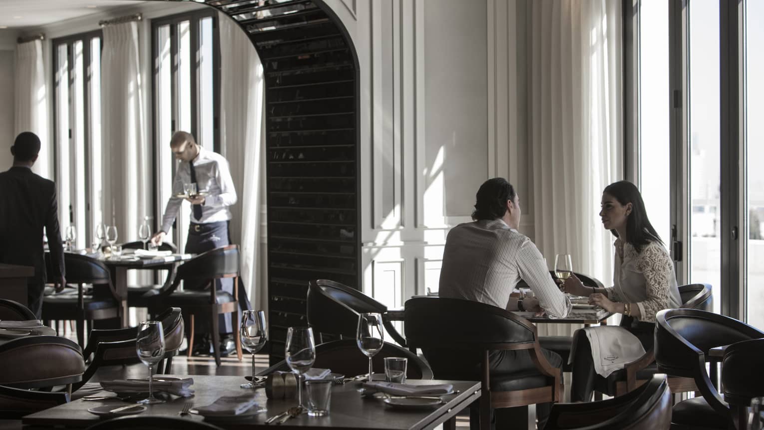 Couple dines by sunny window in modern La Capitale dining room