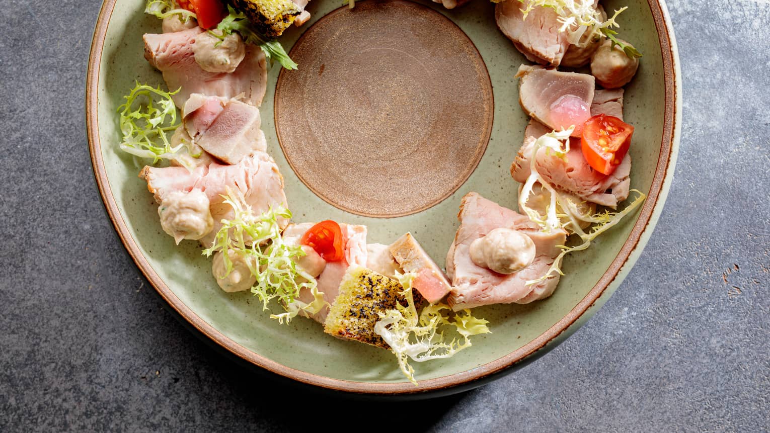 A round plate of veal and vegetables.