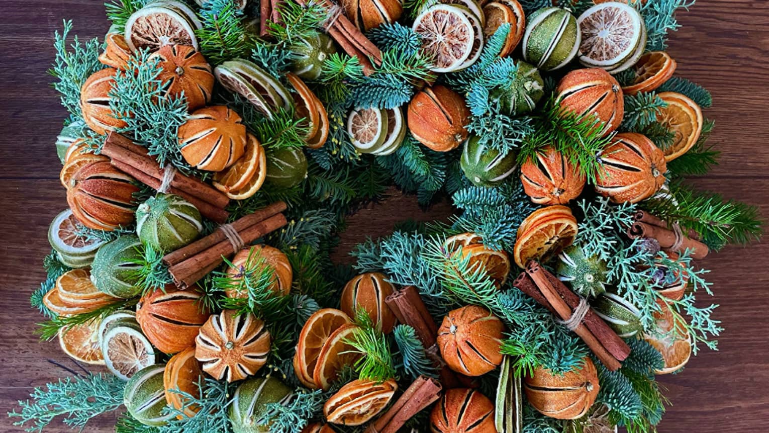 A wreath with greens and oranges.