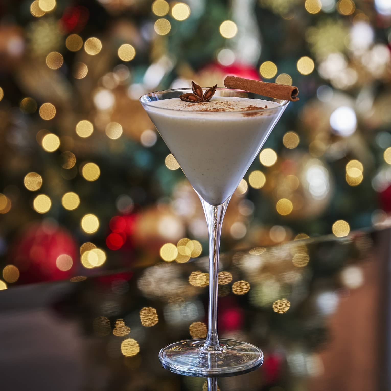 A cocktail in front of a Christmas tree.