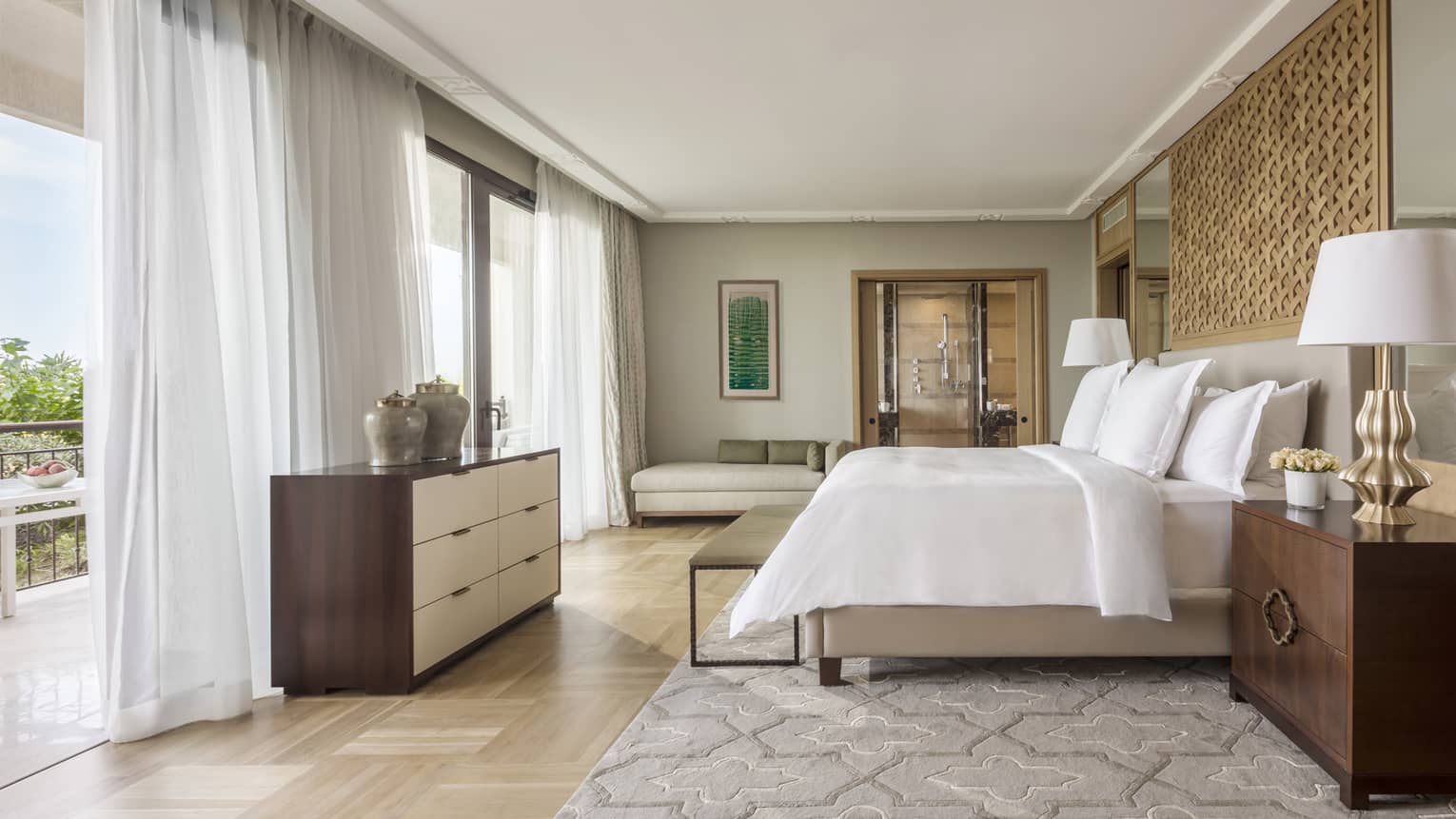Light-filled Mediterranean Suite, bed with white bedding faces floor to ceiling windows with sheer curtains