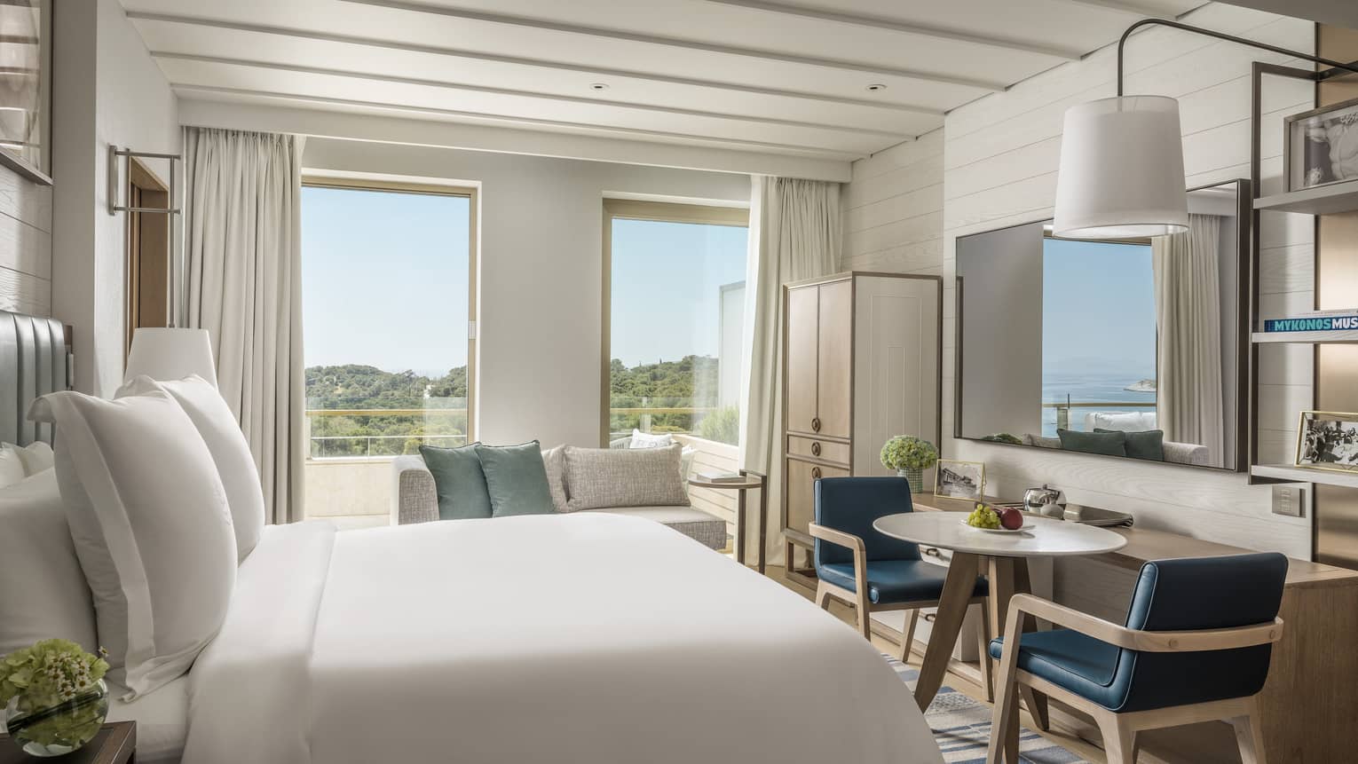 Stylish Arion Pine View Room with white bedding, blue accent furniture and views of trees