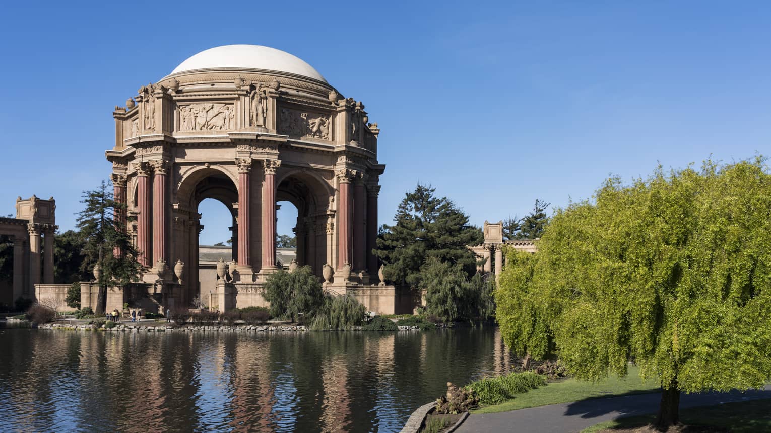 A large domed structure near water and plants.