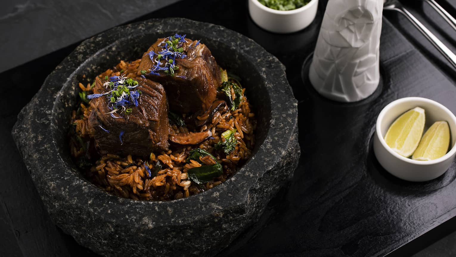 Wagyu ribs, jasmine rice, shiitake mushrooms, Chinese chive, bok choy sprouts, own jus and spring onions served in a black stone pot