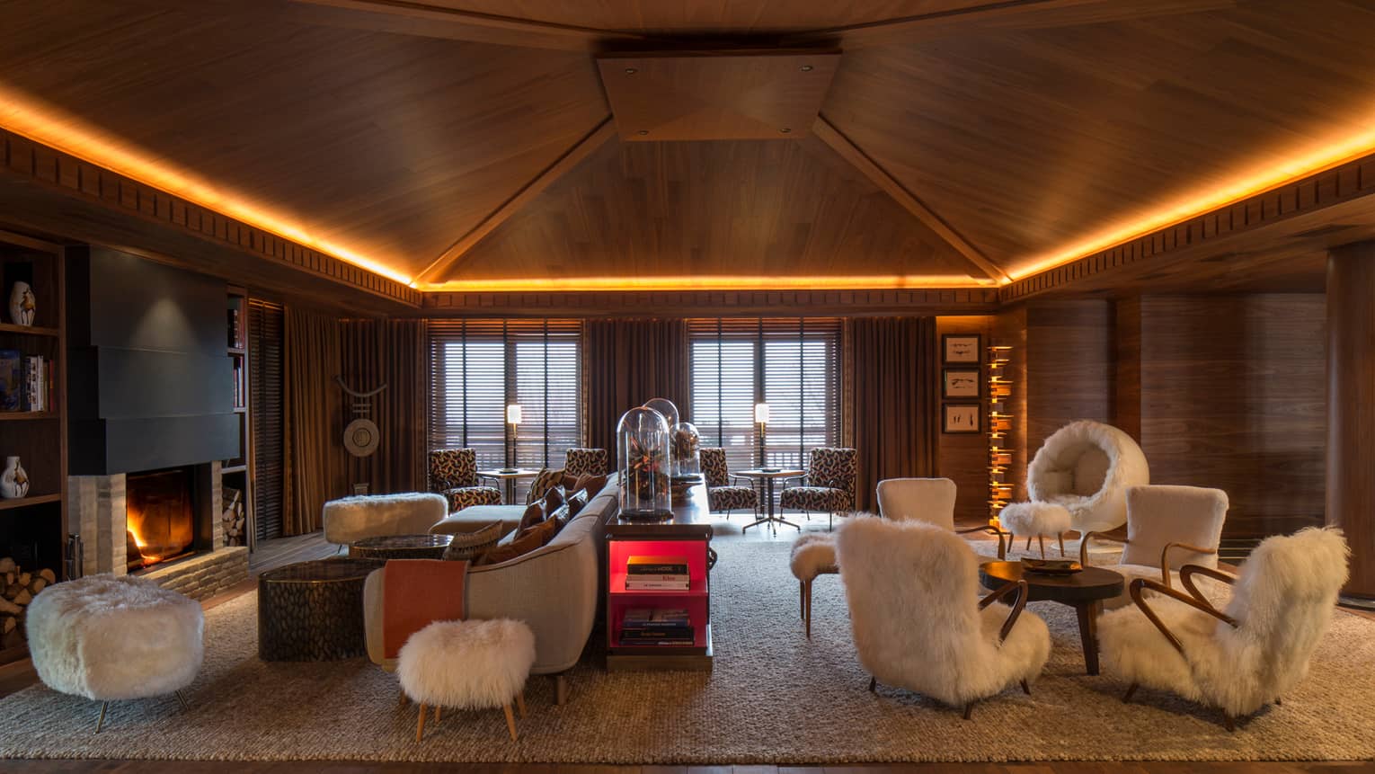 Lobby Lounge wood angular ceiling with lights over retro-style furniture, white faux fur chairs