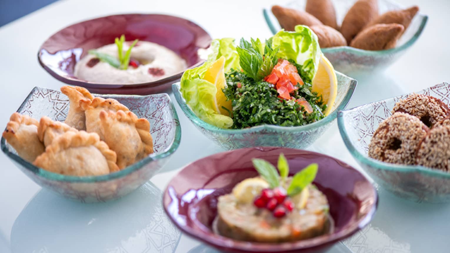 Several bowls filled with fried goods and vegetables.