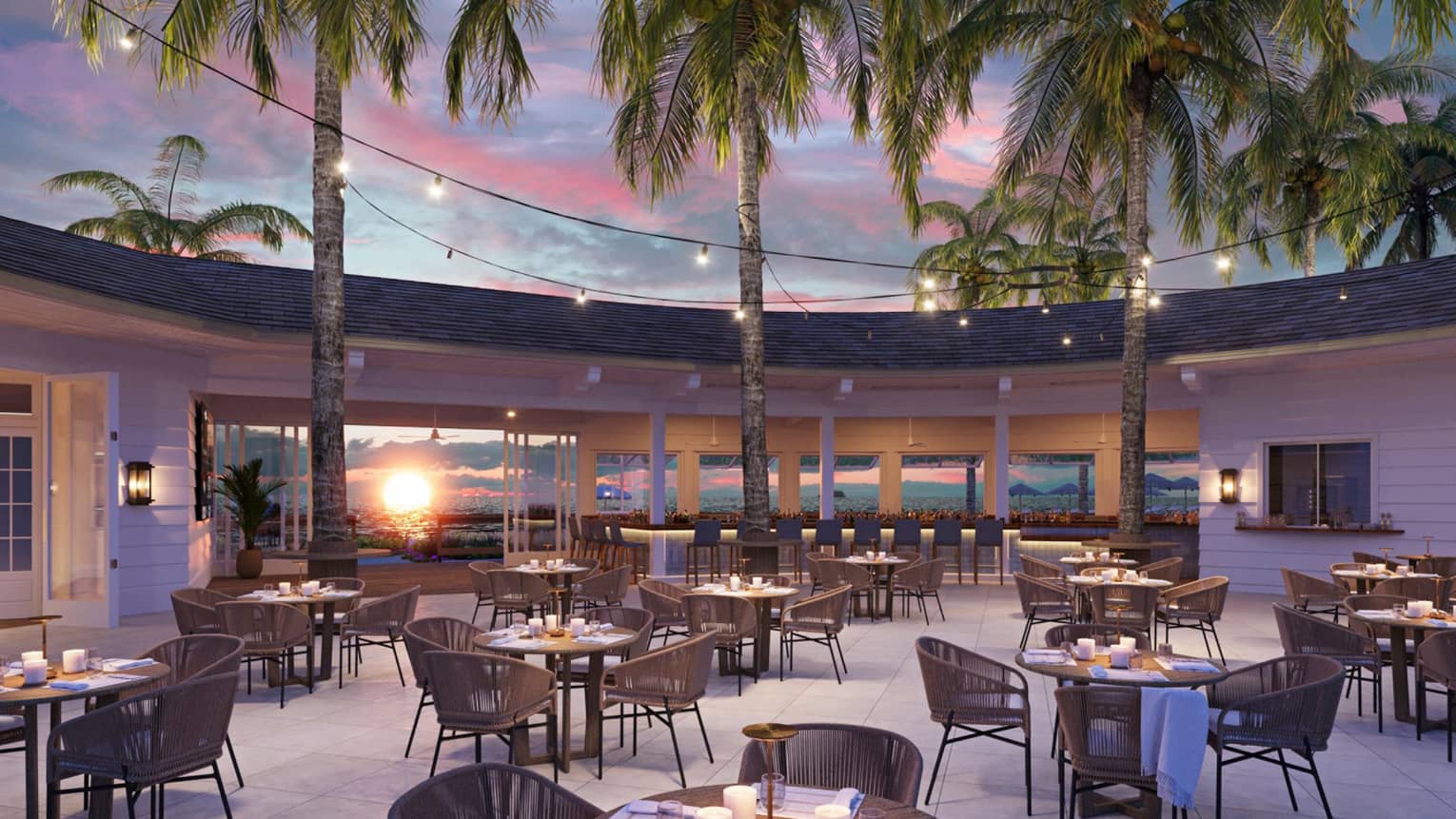 An outdoor bar with table seating near the beach at sunset