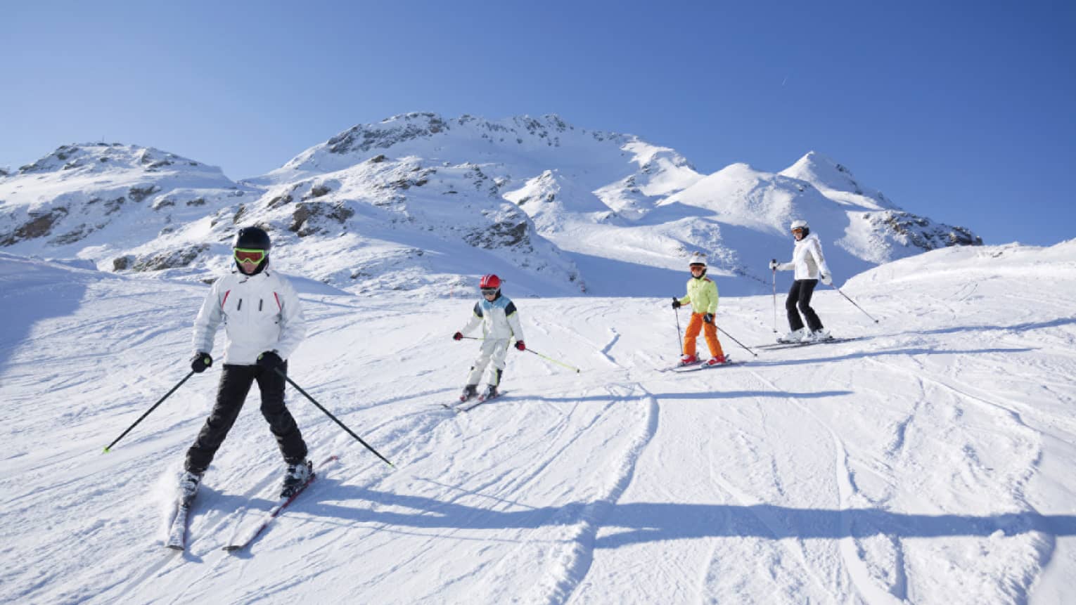 Family skis down snowy mountain