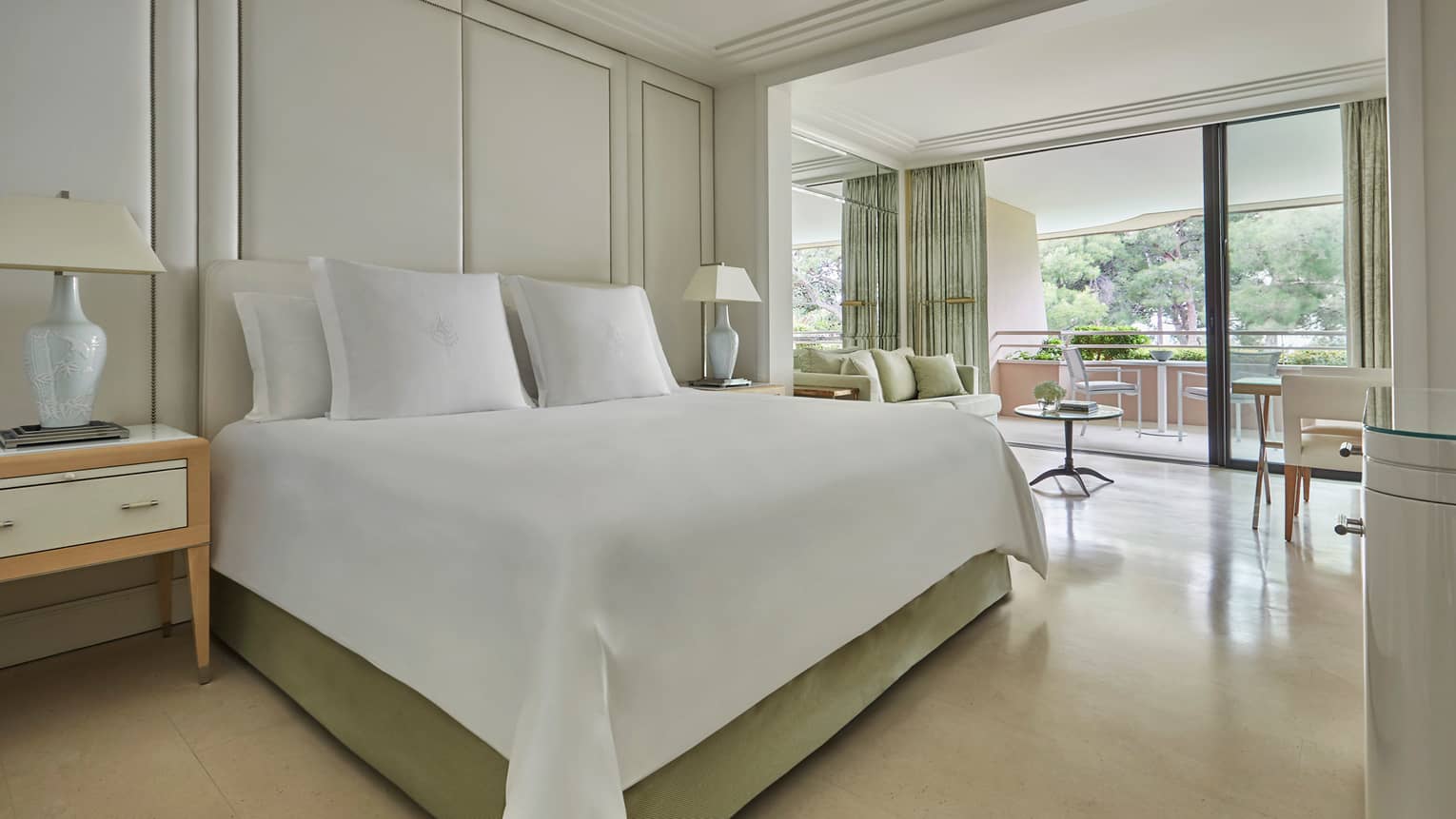 Deluxe Terrace Room modern white hotel room with beds, lamps, open wall to patio
