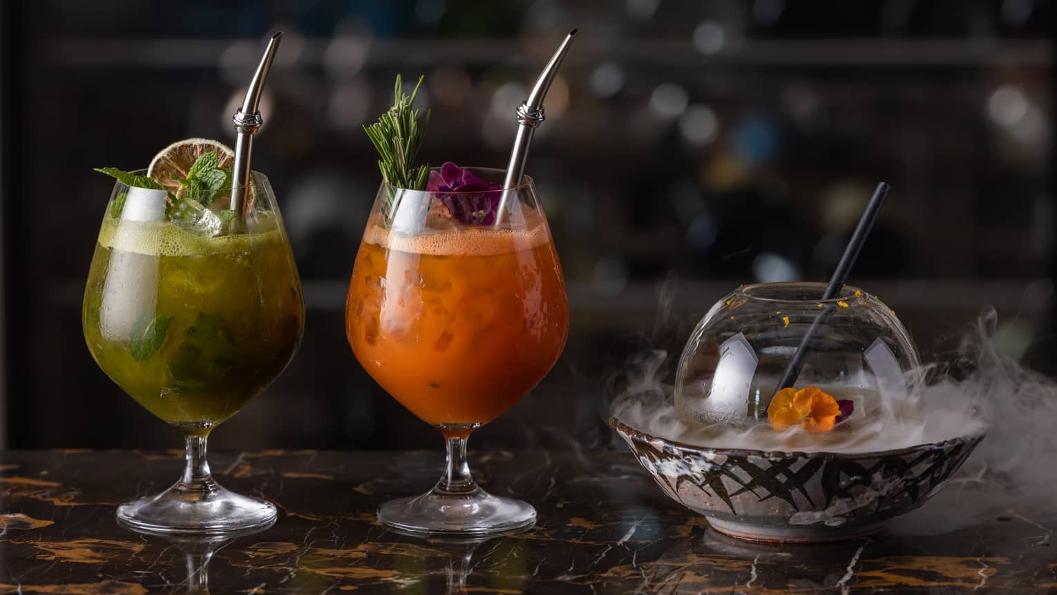 Two summer cocktails available at The Lounge, with cloche over bowl