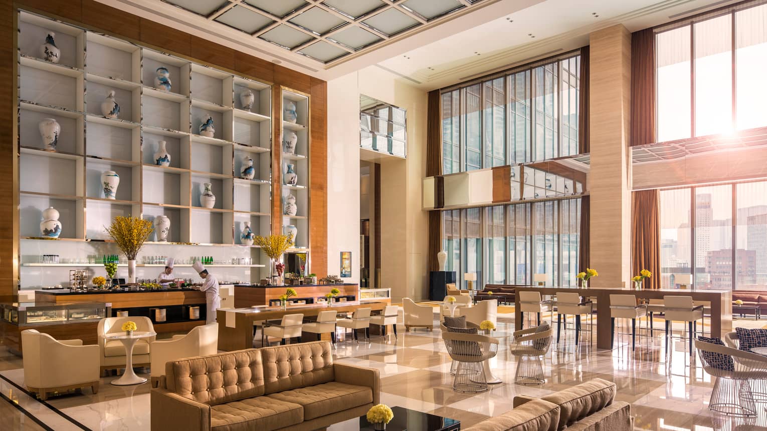 Large wall with blue and white ceramic vases over chefs at bar, bright modern dining lounge