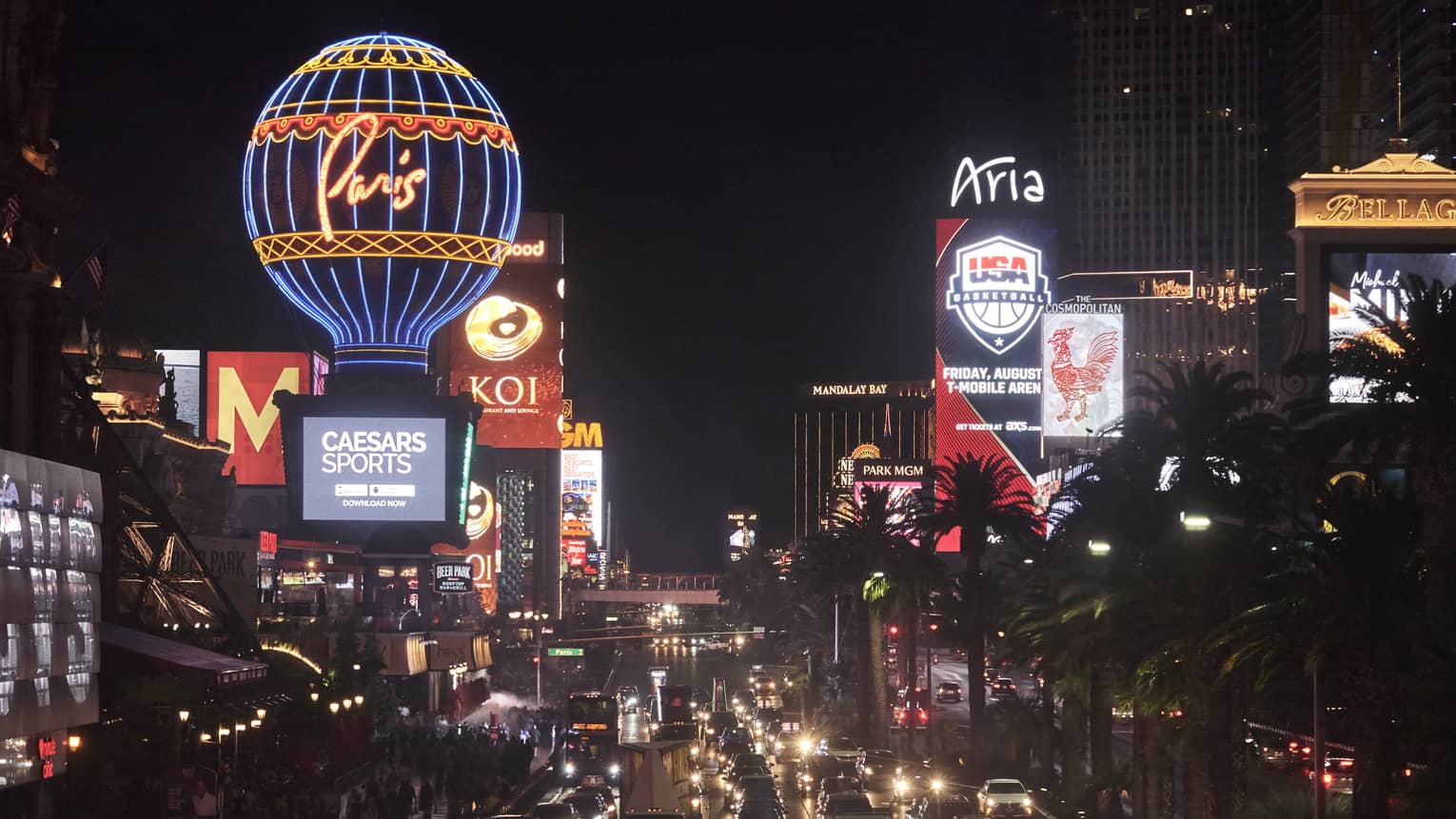 A city skyline with large bright signs and screens on buildings.