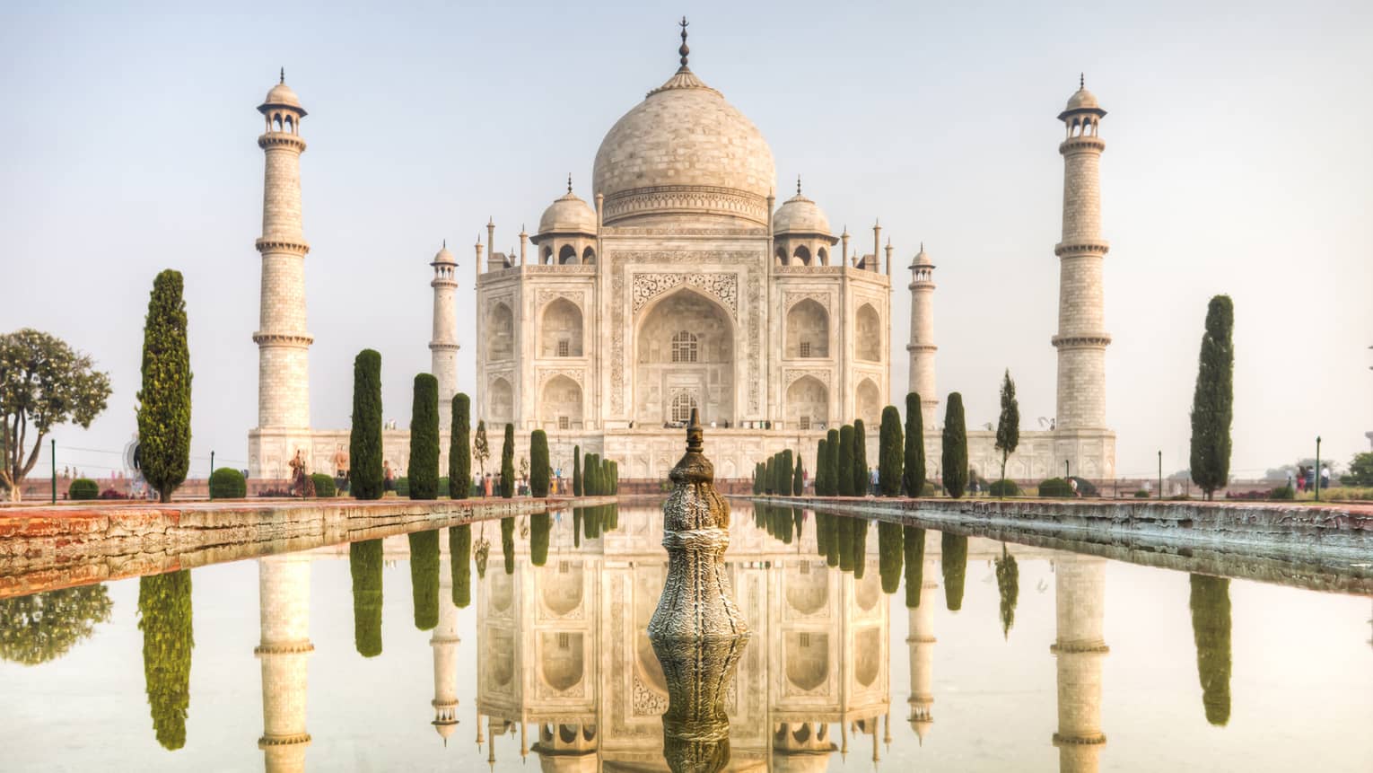 Clear water mirrors the reflection of the Taj Mahal