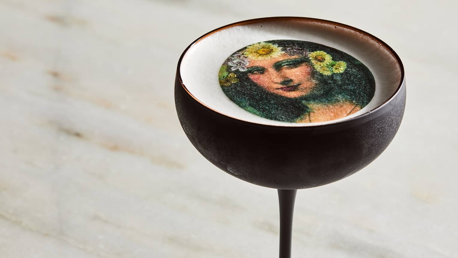 A wine glass with artwork in the drink.