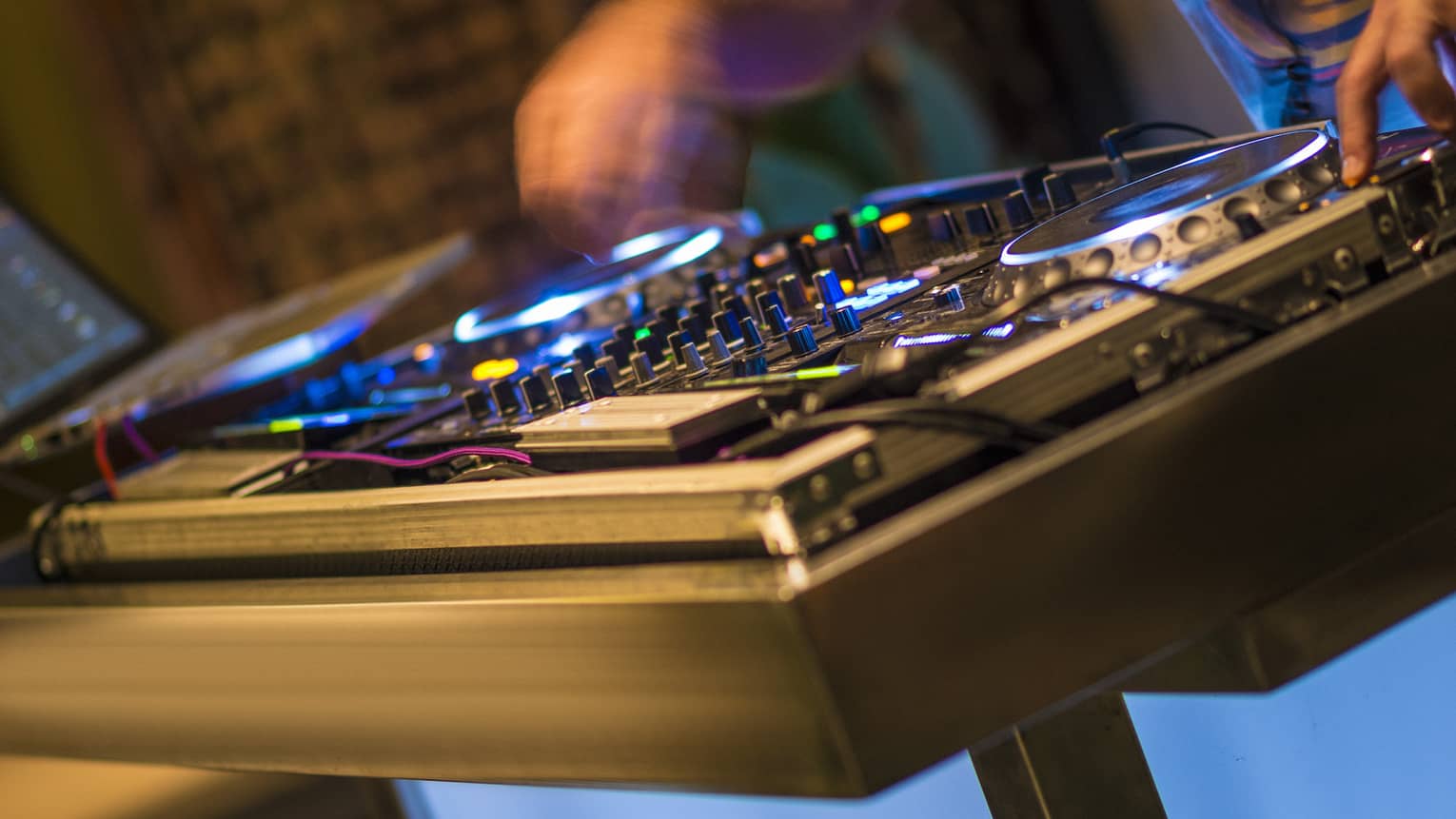 DJ at turntable with lights at night