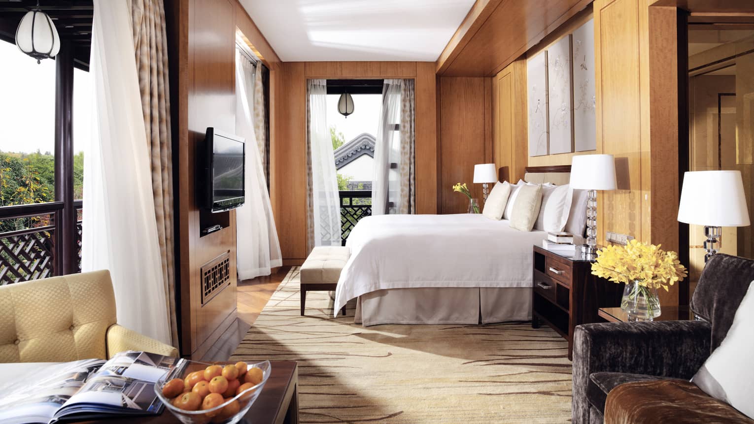 Executive Grand Premier room bed by open corner windows with sheer white curtains