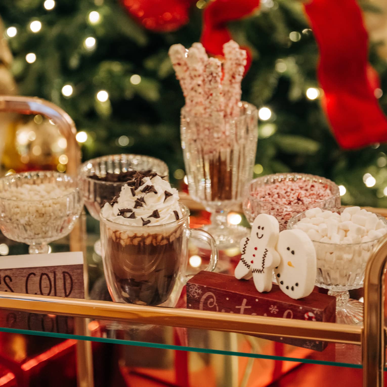 Gold and glass beverage cart carrying hot chocolate and festive toppings