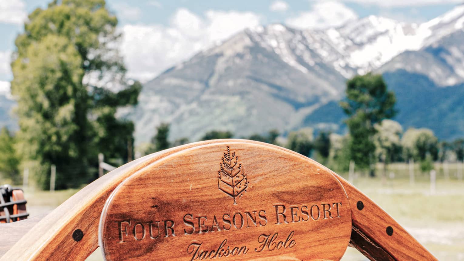 Close-up of the Four Seasons Jackson Hole logo engraved on a wooden plaque near the helm of a boat