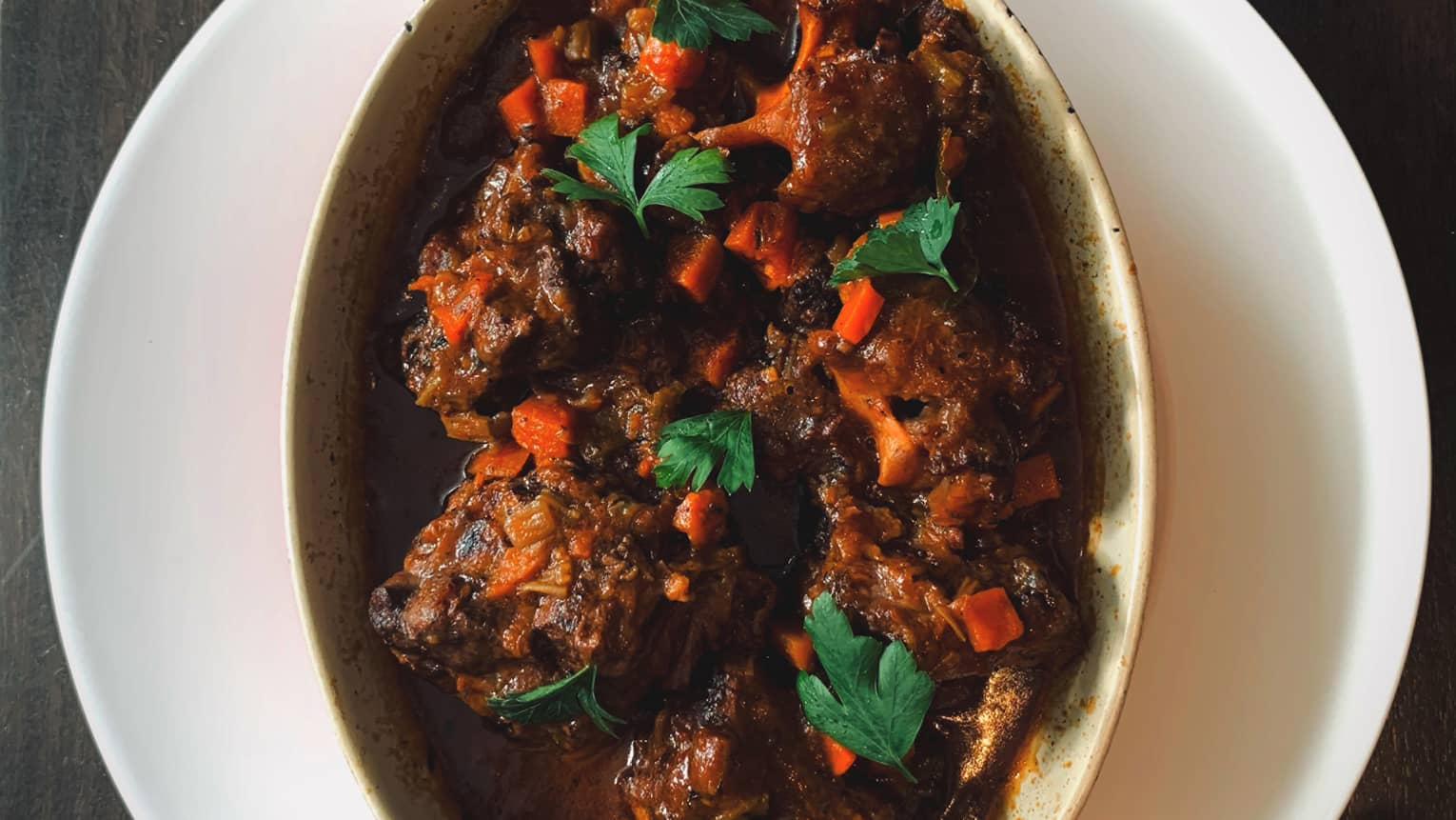 Braised oxtail served in a ceramic dish.