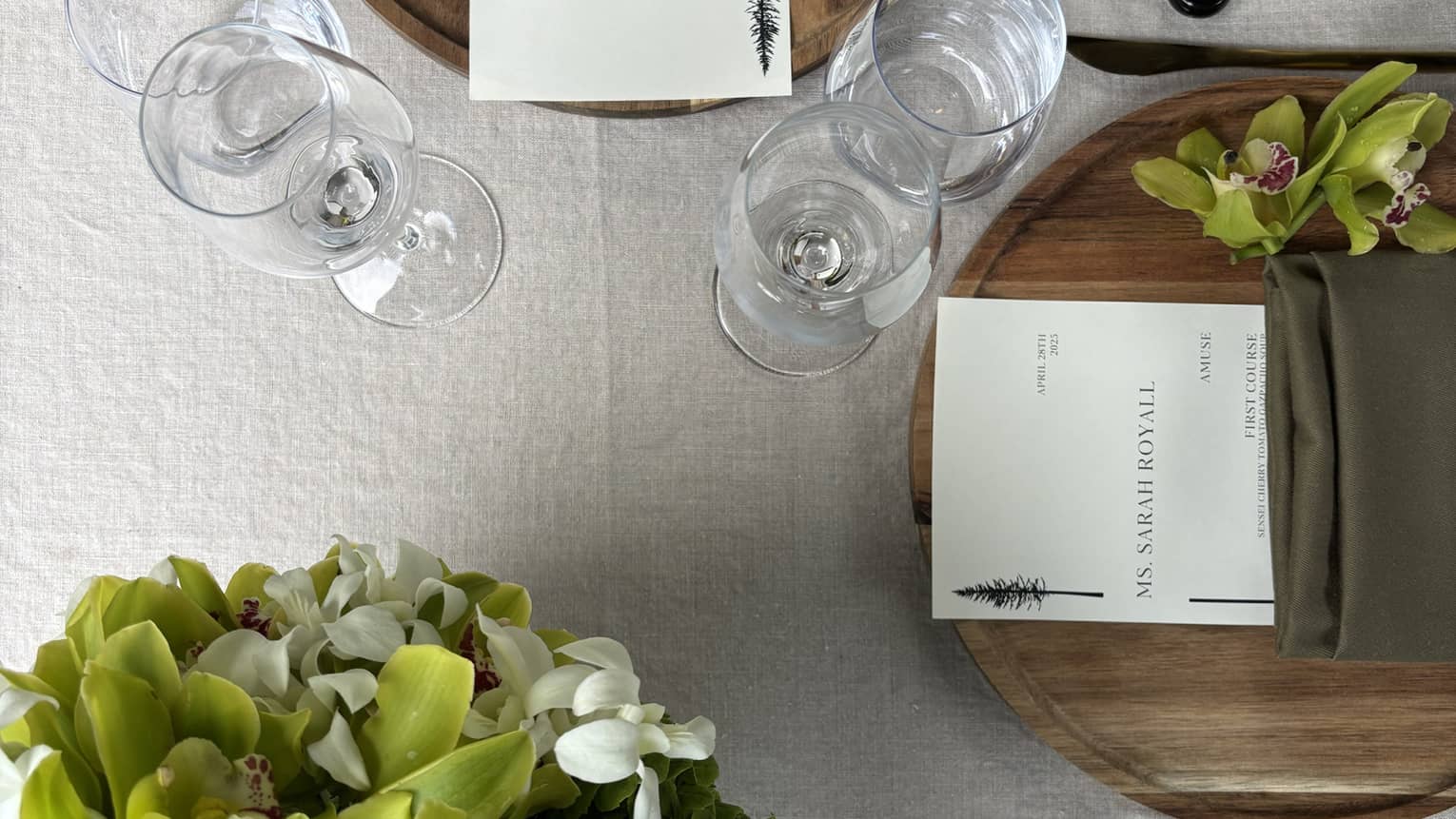 Table setting for two with green floral arrangement
