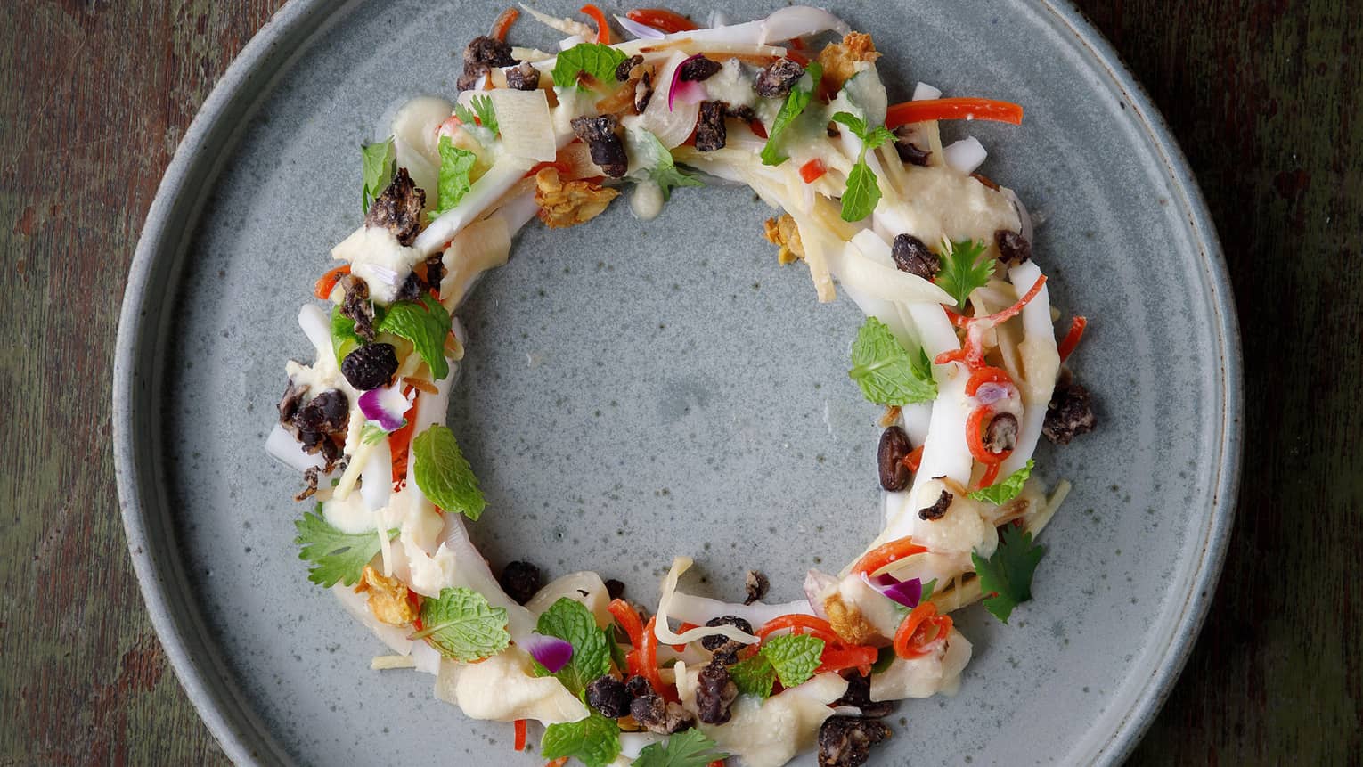A colourful dish of food on a grey plate.