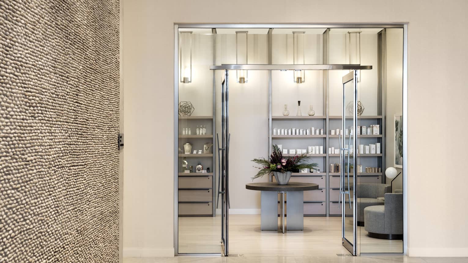 The entrance to a spa with a large glass door.