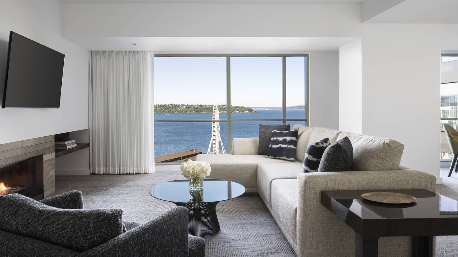 The living room's floor-to-ceiling windows look at to Elliot Bay in the Deluxe Elliot Bay Suite
